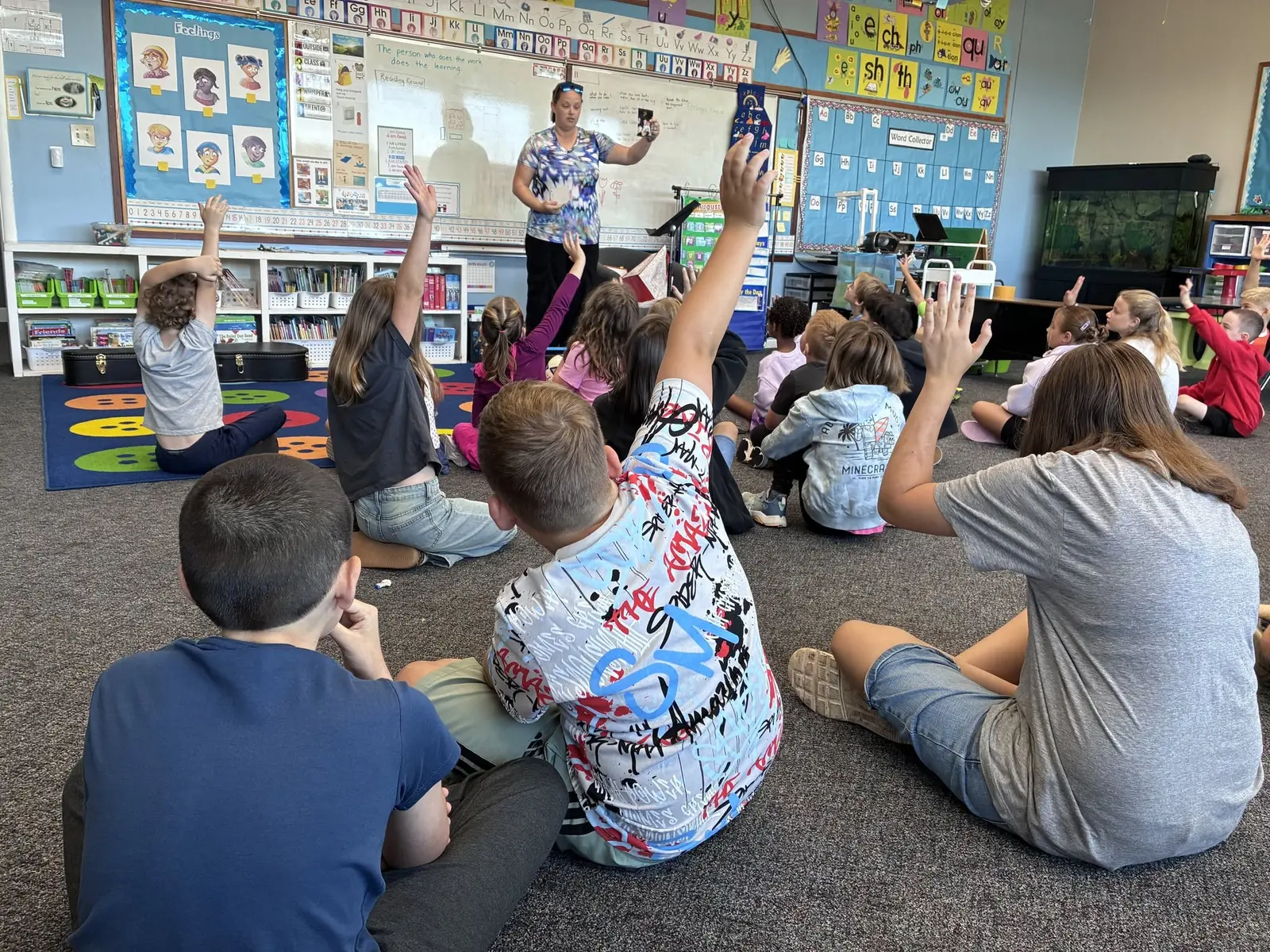 A teacher leading morning worship while students raise their hands