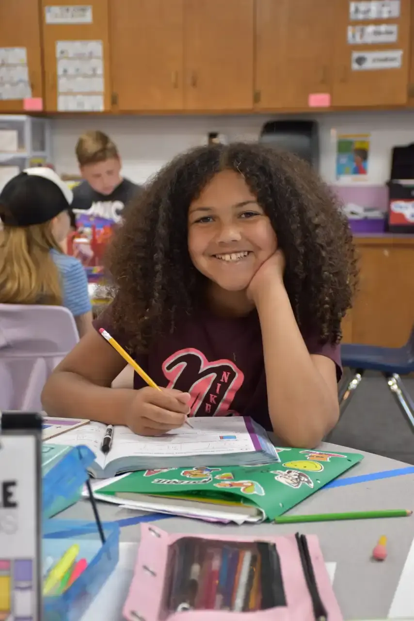 A student smiling over her work