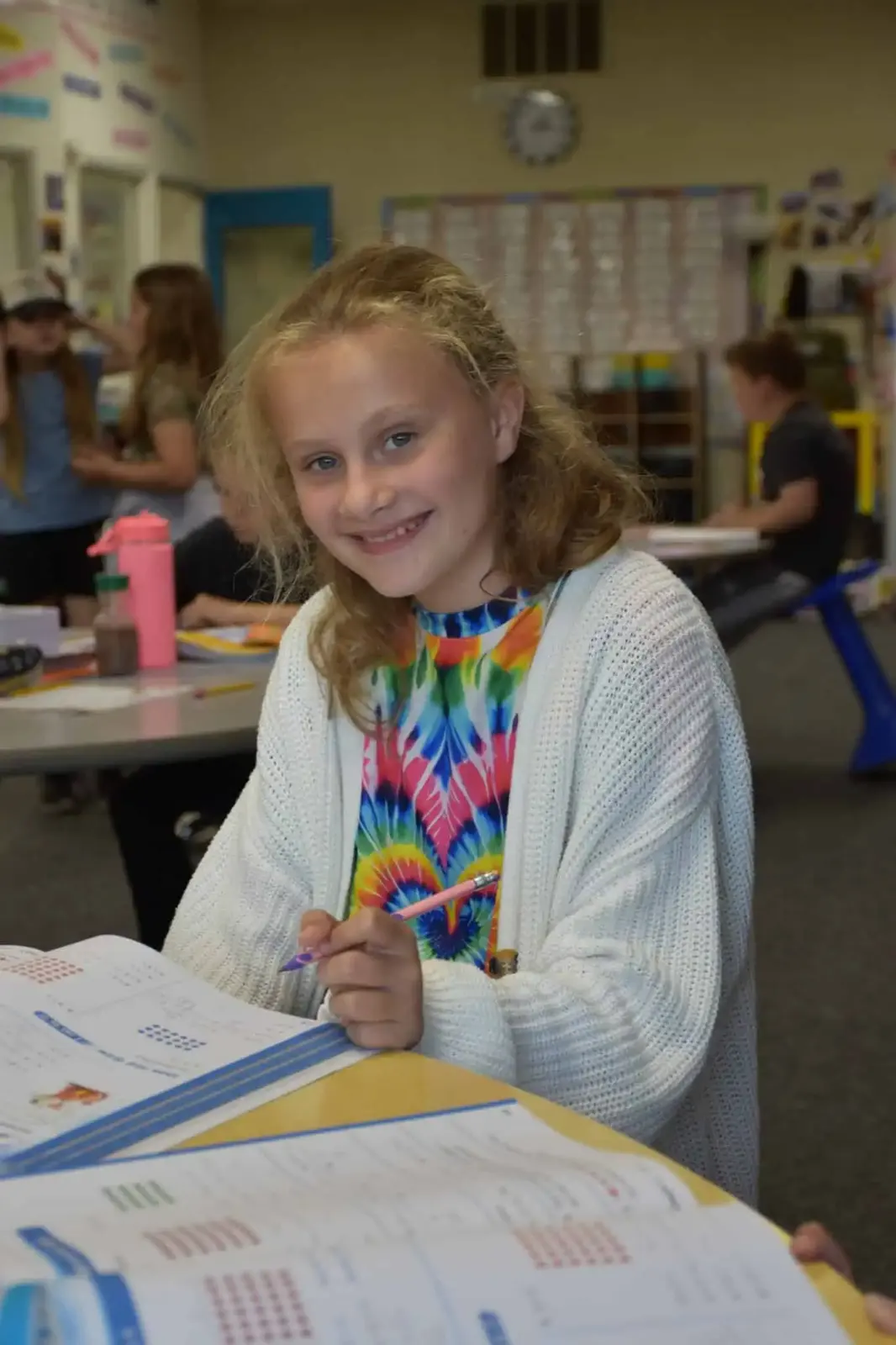 A student smiling over her workbook
