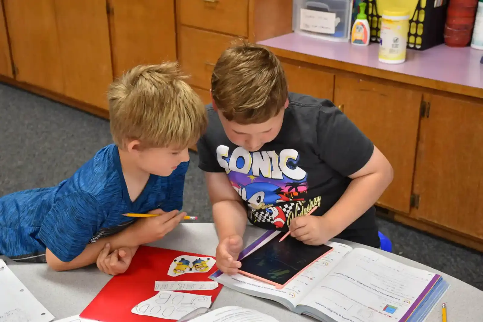 Two boys reading together on the classroom floor