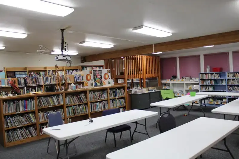 The CVCS library with full bookshelves and long reading tables