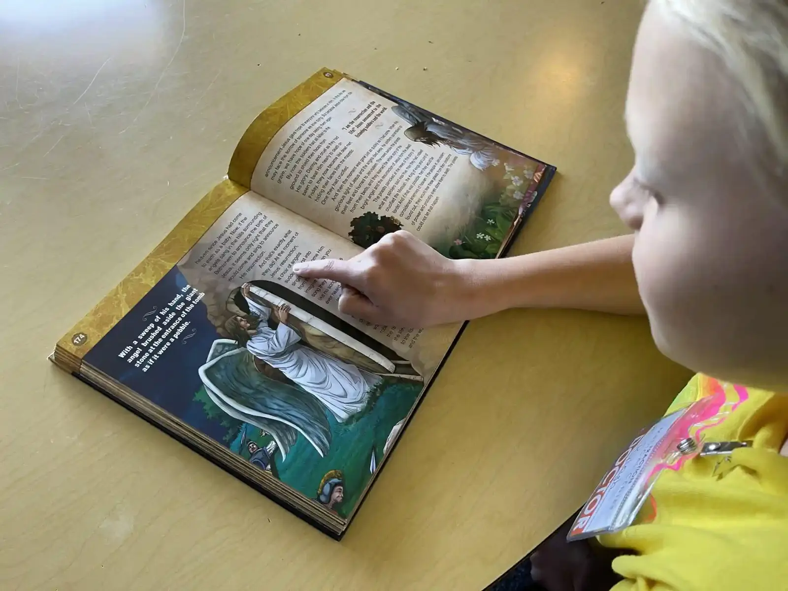 A student reading a Bible storybook at her desk